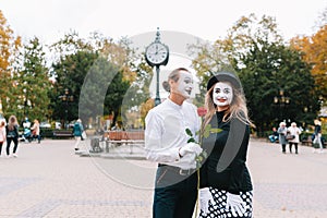 A couple of merry mimes. He hurries on a date