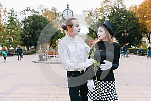 A couple of merry mimes. He hurries on a date