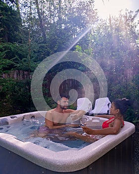 Couple mid age enjoying in a romantic atmosphere of a luxury spa wellness resort, having a bath in a jacuzzi tub