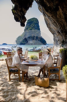 couple mid age on tropical beach in Thailand, tourist walking on a white tropical beach, Railay beach with on the