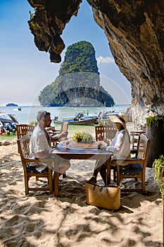 couple mid age on tropical beach in Thailand, tourist walking on a white tropical beach, Railay beach with on the