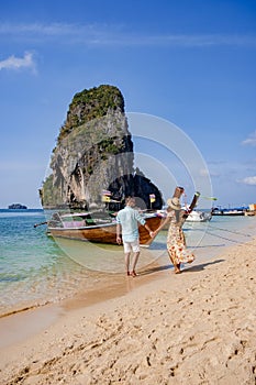 couple mid age on tropical beach in Thailand, tourist walking on a white tropical beach, Railay beach with on the