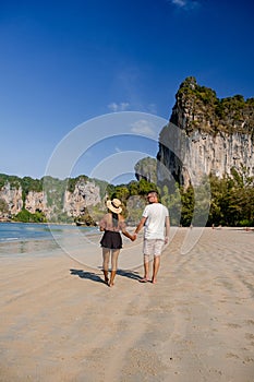 couple mid age on tropical beach in Thailand, tourist walking on a white tropical beach, Railay beach with on the