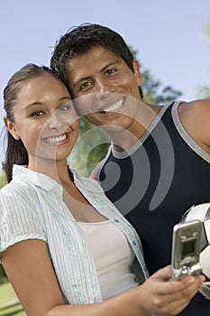Couple With Mobilephone Enjoying Picnic At Park