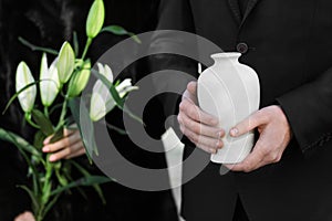 Couple with mortuary urn and flowers at funeral