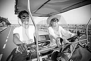 Couple of mother and son having fun together very happy sitted on a doble bike and riding it together - vacation and travelers