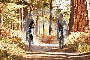 Couple mountain biking through forest, Big Bear, California