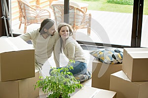 Couple moved in new house sitting on floor with boxes