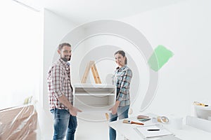 Couple moving furnishings in their new house photo