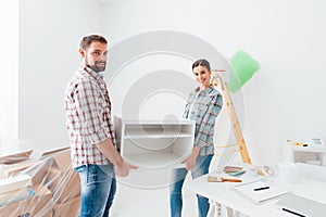 Couple moving furnishings in their new house photo