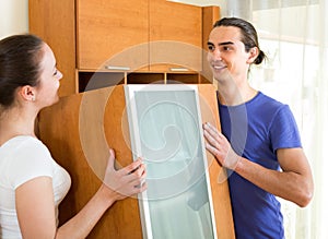 Couple moving furniture in room