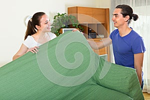 Couple moving furniture in room