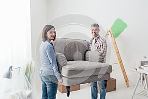 Couple moving furniture in their new house