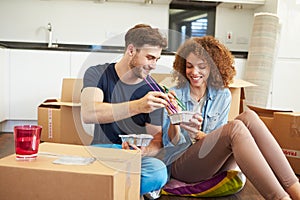 Couple Moving Into New Home Enjoying Takeaway Meal