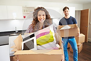 Couple Moving Into New Home And Unpacking Boxes