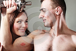 Couple muscular man and girl admiring his strength.