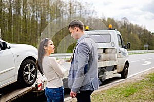 Couple near broken car on a roadside