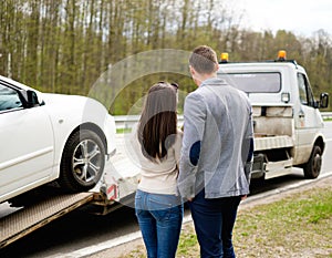 Couple near broken car on a roadside