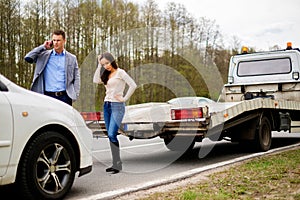 Couple near broken car on a roadside