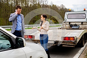 Couple near broken car on a roadside