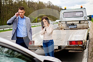 Couple near broken car on a roadside