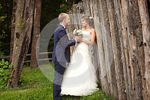 Couple near wooden fence in summer park
