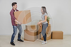 Couple in a new flat. Young man is totaly exhausted. He can not hold heavy box anymore, but woman doesn`t know where to