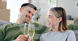 Couple, new home and toast champagne on sofa for celebration with boxes in living room together. Man, woman and wine
