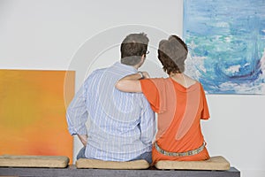 Couple Observing Painting In Art Gallery photo