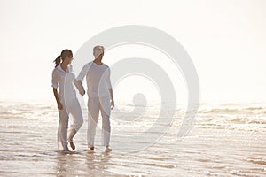 Couple, ocean and holding hands on beach, travel and commitment with trust and bonding with walking outdoor. Love, care