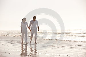 Couple, ocean and holding hands while walking on beach, travel and commitment with trust and bonding outdoor. Love, care