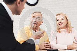 A couple of old people came to a consultation with a lawyer. The lawyer communicates with a man and a woman.