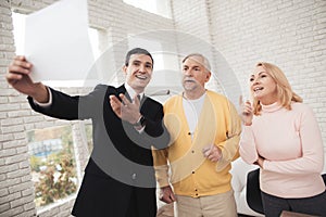 A couple of old people at lawyer`s reception. Lawyer stands before them and enthusiastically talks about upcoming deal.