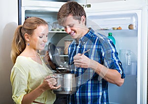 Couple opened fridge looking food photo