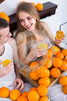 Couple with orange juice in bed