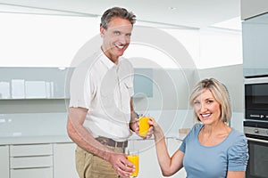 Couple with orange juices having breakfast in kitchen