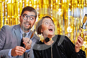 Couple over gold with photo booth accessories on party