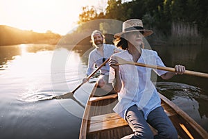 Couple paddling canoe on lake