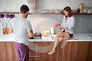 Couple in pajamas prepare breakfast together