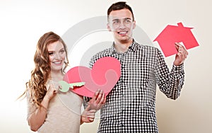 Couple with paper house and heart love symbol.