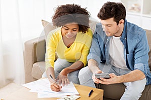 Couple with papers and calculator at home