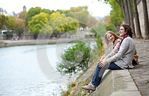 Couple in Paris, sitting at the edge of water