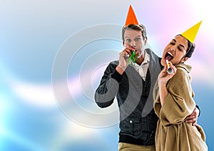Couple with party hats against blurry blue abstract background
