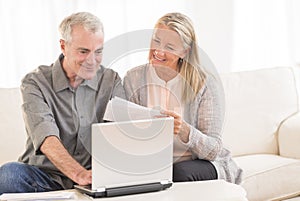 Couple Paying Bills Through Laptop At Home