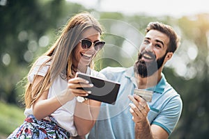 Couple paying on line with credit card and digital tablet outdoor