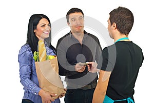 Couple paying with money at supermarket