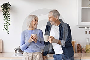 Couple of pensioners drinking coffee at kitchen