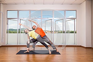 Couple perform series of Extended Side Angle yoga partner pose