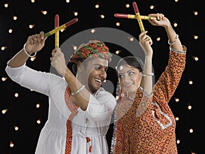 Couple performing Dandiya Raas on Navratri