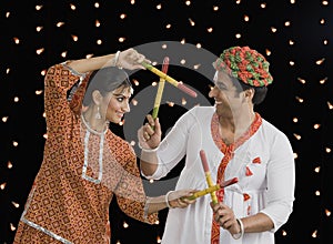 Couple performing Dandiya Raas on Navratri